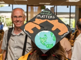 Student's decorated cap says "every individual matters"
